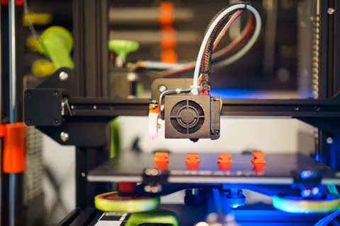 3D printer head printing a row of small parts