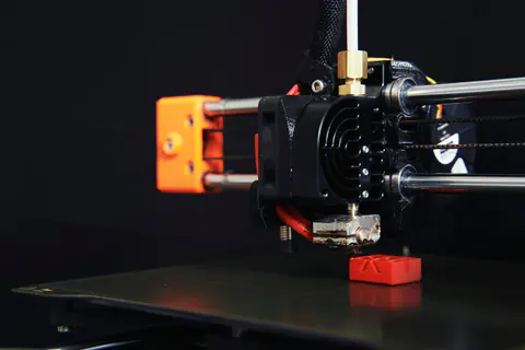 Ugello di una stampante 3D FDM che stampa un pezzo rosso
